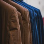 Showcase of neatly arranged brown and blue jackets on hangers, emphasizing fashion and style.